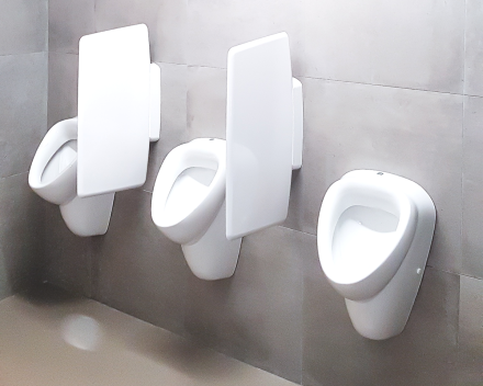 De praktische toiletruimte voor de mannen in een bedrijfsgebouw